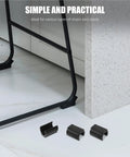 Three black U Shaped Floor Glides For Hardwood Floors 48 Pack Chair Leg Caps with No Slip Ribbed Surface on white floor with chair leg.