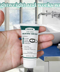 Front view of KEZE food-grade silicone grease tube, 1 oz, held in hand near a bathroom faucet.