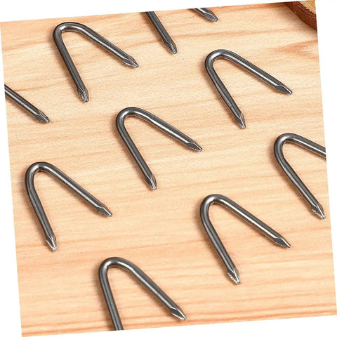 U Shaped Garden Stakes And Fence Nails 100 Pack For Fast Easy No Fuss Installation And Heavy Duty Fixes For Fences Anchors And Garden Decor Ideal For Large Area Projects DIY Landscaping. Shown on wooden surface.