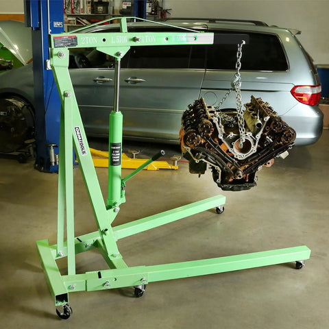 Straight Shooter Two Ton Engine Hoist Foldable Cherry Picker Shop Crane with engine suspended, hydraulic lift visible in garage.