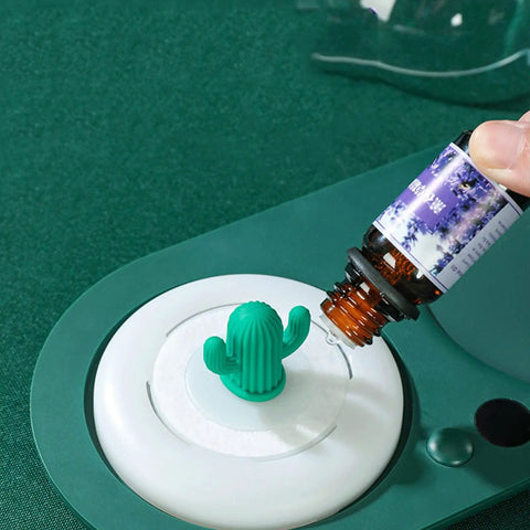 Smart Cup Warmer Heating Pad With Adjustable Temperature Controls Keeping a cactus-shaped essential oil dropper on a marble base.