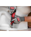 Pro Grade M12 Cordless Brushless Rotary Tool With Snappy Variable Speed Dial And 12 Precision Settings delivering precise cuts on a toilet.