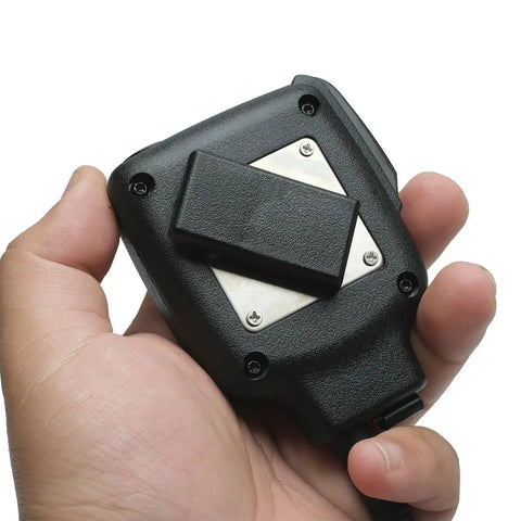 Hand holding hands free speaker microphone for Kenwood Radios NX and TK series, black rugged back view with clip.