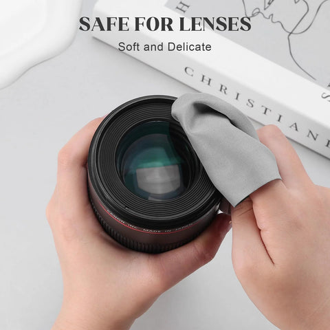 Navona microfiber cleaning cloth for lenses, gray, being used to wipe a camera lens (close-up view)