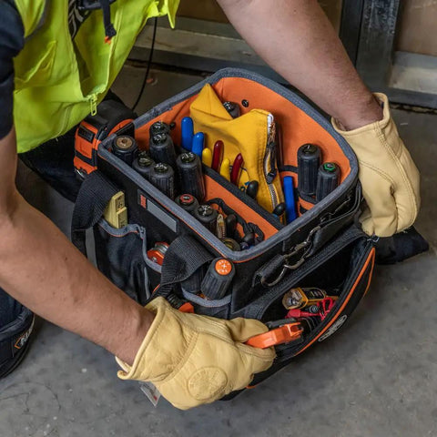 Contractor using Heavy Duty Tool Bag With Shoulder Strap And 40 Pockets In Bright Orange Interior For Fast Tool Access