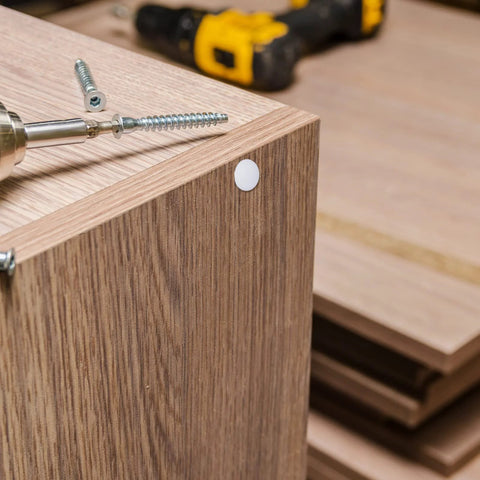 Installed white plastic hole plug in wood cabinet panel, part of Six Sizes White Plastic Hole Plugs Set For Panels And Cabinets Round Knockout Locking Hole Covers Fits Drill Holes In One Quarter Inch One Inch Three Sixteenths Inch Five Sixteenths Inch Three Eighths Inch And One Half Inch 135 Pieces