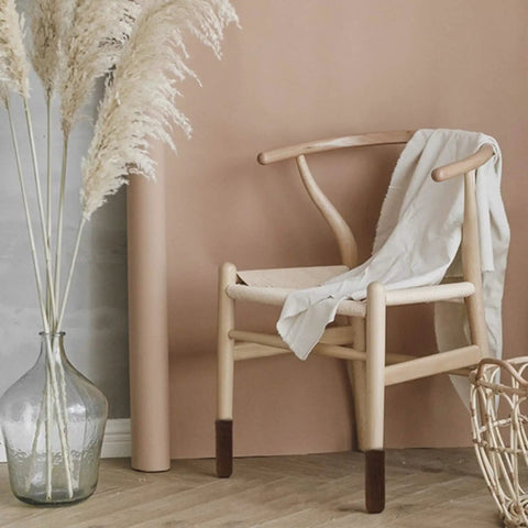 Wooden chair with a draped cloth and 32 Pack Coffee Colored Furniture Leg Socks With Double Thick Elastic Covers, in a cozy setting.