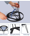 Person folding Portable Camping Tripod Stand for Bonfire Fire Pit in heavy duty iron black, showing the stable structure and sturdy legs.