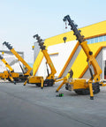 Three Portable Mini Crawler Cranes With Wireless Handheld Transmitter And Dependable Hydraulic Pump outdoor in a work area.