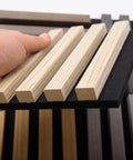 Hand holding Game Changer Acoustic Wood Slat Wall Panels for knockout noise dampening with premium polyester core.