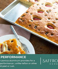 Heavy Duty Aluminum Half Sheet Pan With Stainless Steel Cooling Rack Set, 13x18 Inches, with baked cake on top, placed on wooden surface.