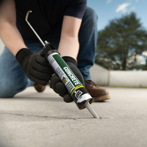 Person applying Concrete And Mortar Filler And Sealant In Gray For Interior And Exterior Cracks And Holes DIY Friendly