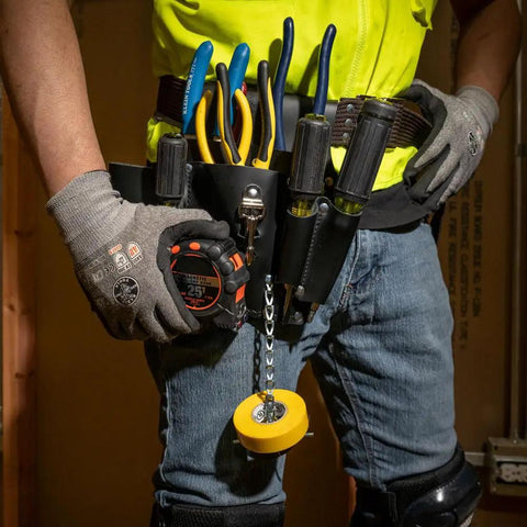 Person wearing Leather Tool Pouch Go-To 8 Pocket Carry System, holding pliers and tools, belt clip visible, knife snap shown