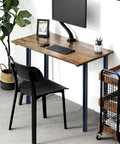 Adjustable 28 Inch Metal Desk Legs Set Of 4 In Heavy Duty Black Finish For Office Desks And Tables One Point Five Inch Diameter Height Adjusts About Point Seven Inch Includes Mounting Plates And Screws For Easy DIY Furniture Upgrade supporting a wooden desk