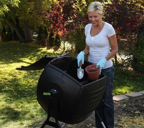 50 Gallon Compost Tumbler In Black No Fuss Easy Spin Barrel For Lawn Clippings And Kitchen Scraps used by woman in garden