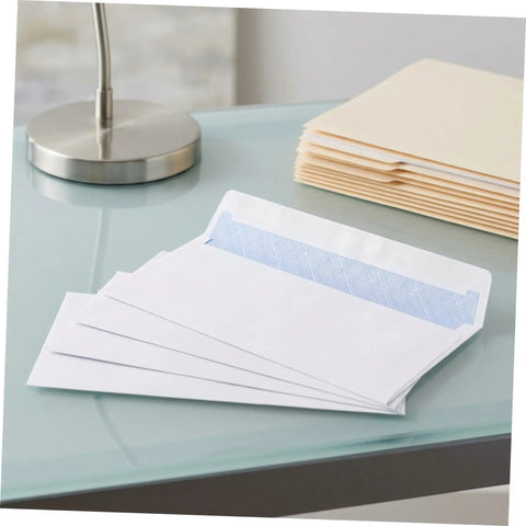 White Pro-Grade Self-Sealing Security Mailing Envelopes 115mm X 225mm shown open on a glass desk with folders
