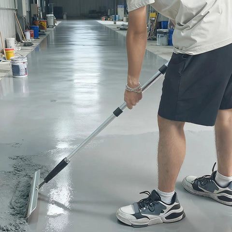 Person using Kick Ass 11 Piece Drywall Tool Set With Telescopic Extension Pole for smoothing floor surface.
