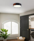 Sleek Modern Black Flush Mount Ceiling Light With 2 Lights, Mid Century Round Wood Accent Fixture in a laundry room.