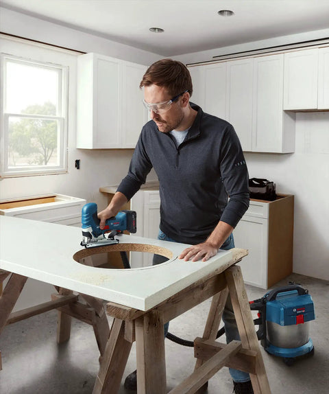 Man using Real Deal 18V Cordless Jigsaw Packing Brushless Muscle And Quick Swap Blades to cut a hole in a countertop.