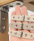 Hand holding Six Piece Folding Door Hinges Set With Rust Resistant Finish Heavy Duty And Easy Install For Furniture And Decor Bulletproof Build Iron Construction 7.8 By 1.7 Cm Great For Cabinets Doors And DIY Projects