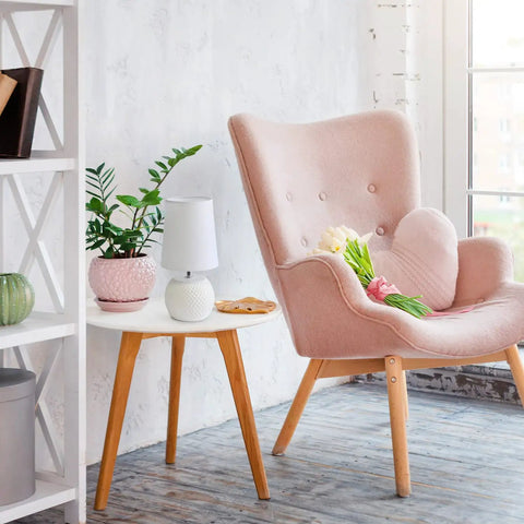 White Ceramic Bedside Lamp With Pink Dotted Texture Shade on a wooden table beside a pink armchair in a cozy room