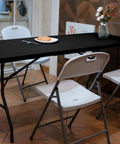 Foldable 6 Foot HDPE Table Go To Portable Banquet Surface Fold In Half Desk Utility with chairs in dining setting, black.