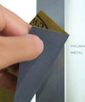 Hand using 24 Pack Sandpaper Variety Kit With 12 Grits From 120 To 3000 For Wood And Metal Sanding on metal surface