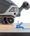 Close-up of Inline T Track Stop For T-Track System With Low-Profile Knobs holding wood against sander on table.