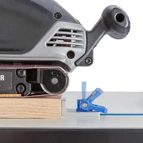 Close-up of Inline T Track Stop For T-Track System With Low-Profile Knobs holding wood against sander on table.