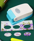 Portable Oval Tab Punch for Scrapbooking and Card Making cutting floral paper on a craft table.