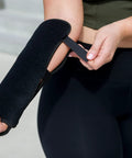 Person demonstrating adjustable fit of Red Light Therapy Wrist Wrap For Pain Relief And Carpal Tunnel Support on arm.