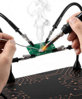 All-in-One Soldering Stand With Four Handy Helping Hands And 5X Magnifier in use, holding a circuit board with soldering iron.