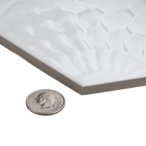 Close-up of White Hex Porcelain Tile For Floor And Wall, 8.63 In Width By 9.88 In Length, next to a quarter for size comparison.