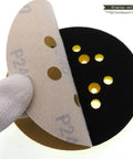 Premium 5 Inch Dry Sanding Discs With Hook Loop System Featuring Durable Aluminum Oxide Abrasive Paper showing eight holes for dust extraction.