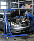 1.5 Ton Hydraulic Engine Hoist With Telescoping Boom Shop Crane lifting car engine in garage, mechanic working