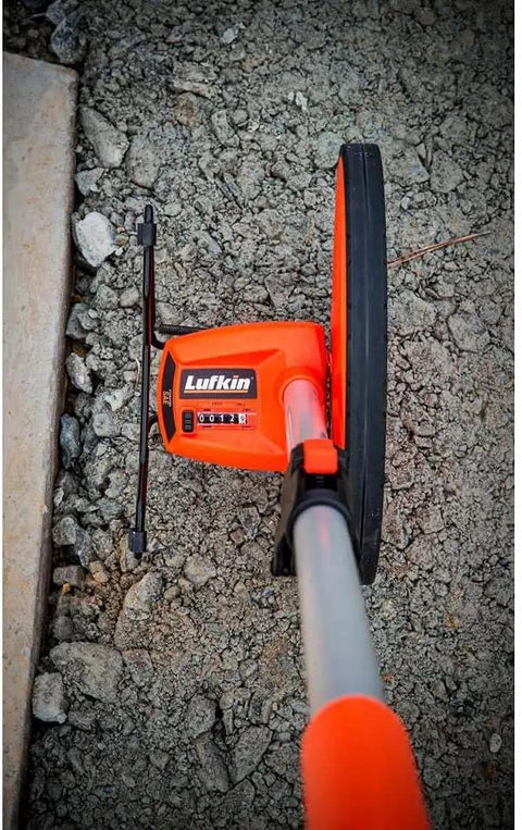 12 Inch Pro SAE Measuring Wheel With Centerline Wheel, showing gear based counter on rocky surface