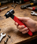 Hand holding Double Head Four Claw Spanner For Angle Grinder Quick Disc Change, Hex Socket End, on workbench