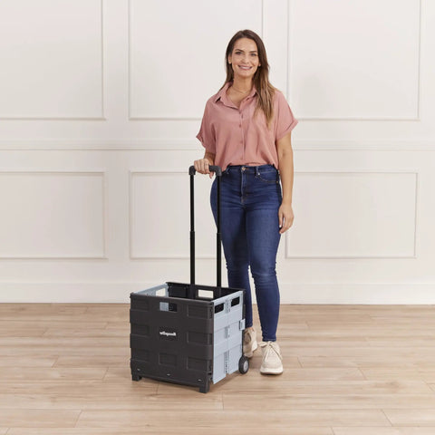 Woman holding Collapsible Rolling Storage Cart On Wheels For Home Office Classroom Use Mobile Organizer With Retractable Handle