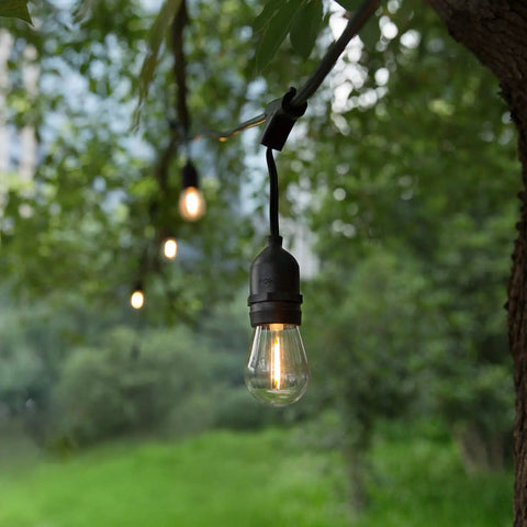 15 Pack Shatterproof S14 LED Bulbs 1W Warm White 2200K for outdoor string lights hanging in a garden setting