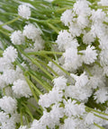Bundle of delicate white faux flowers with green stems, ideal for decorative arrangements.