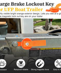 Orange magnetic surge brake lockout key with easy-release strap attached to a boat trailer hitch