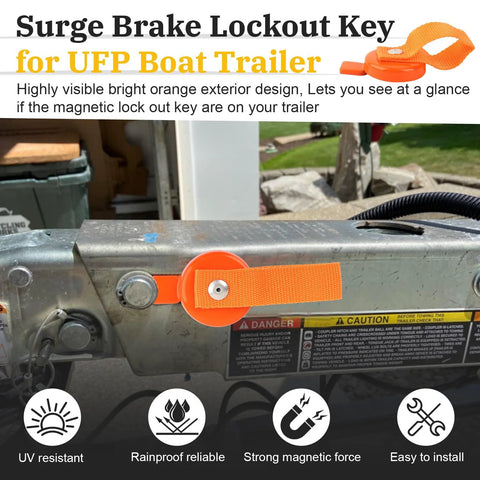 Orange magnetic surge brake lockout key with easy-release strap attached to a boat trailer hitch