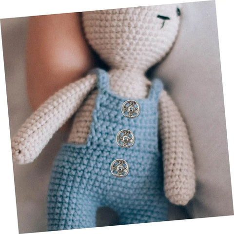 Close-up of doll wearing overalls with 120Pcs Tiny Round Snap Fasteners from Mini Colored Button Set for Doll Clothes and DIY Sewing Projects.