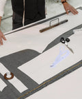 Cordless Electric Fabric Scissors With Safety Lock Cut Leather Cloth And Paper Under 25mm Thickness Battery Powered Handheld Design For Sewing And Crafting No Messy Cords Easy To Use Replaceable Blade on a sewing table with fabric and patterns.