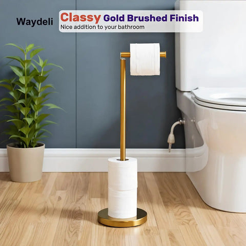 Freestanding Toilet Paper Holder Stand With Reserve For Four Spare Rolls, Sturdy Base, Stainless Steel Construction With Brushed Nickel Finish, No-Fuss Rustproof Bathroom Tissue Roll Storage Shelf in brushed gold finish next to a toilet.