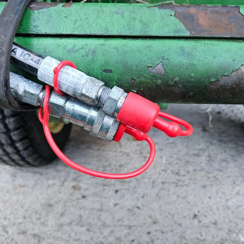 Dust caps for 1/2-inch flat-face hydraulic quick-connects; red rubber covers on metal male/female fittings