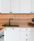 Matte Black Cabinet Knobs 10 Pack Kitchen Drawer Hardware modern round pulls on white cabinetry with wood accents.