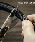 Cutting 5mm black self wrapping wire loom with scissors for custom length, ideal for RV, boat, and auto projects.