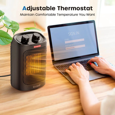Powerful 1500W Portable Space Heater With 60 Degree Oscillation For Indoor Use on desk near laptop, showing adjustable thermostat.