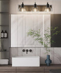 Three Light Matte Black Farmhouse Vanity Lighting Fixture With Clear Glass Globes over bathroom mirror